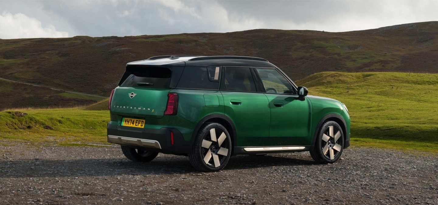 Front view of the all-electric MINI Countryman in Midnight Black and Vibrant Silver Roof on a street.